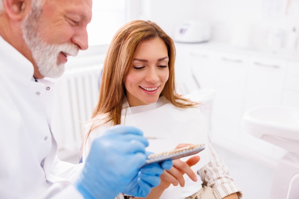 paciente em clínica de odontologia colocando dentes de porcelana